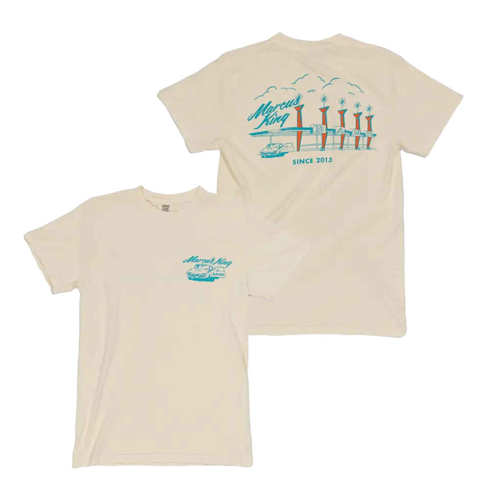 Beige t-shirt with a teal coastal design featuring piers or docks printed on the back.