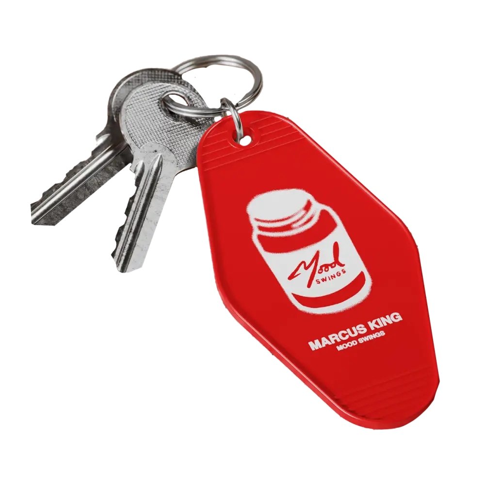 Red key fob with a pill bottle logo and ’Marcus King’ text attached to metal keys.