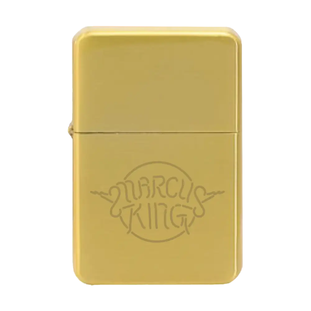 Gold-colored metal lighter with ’Marcus King’ engraved on its surface.