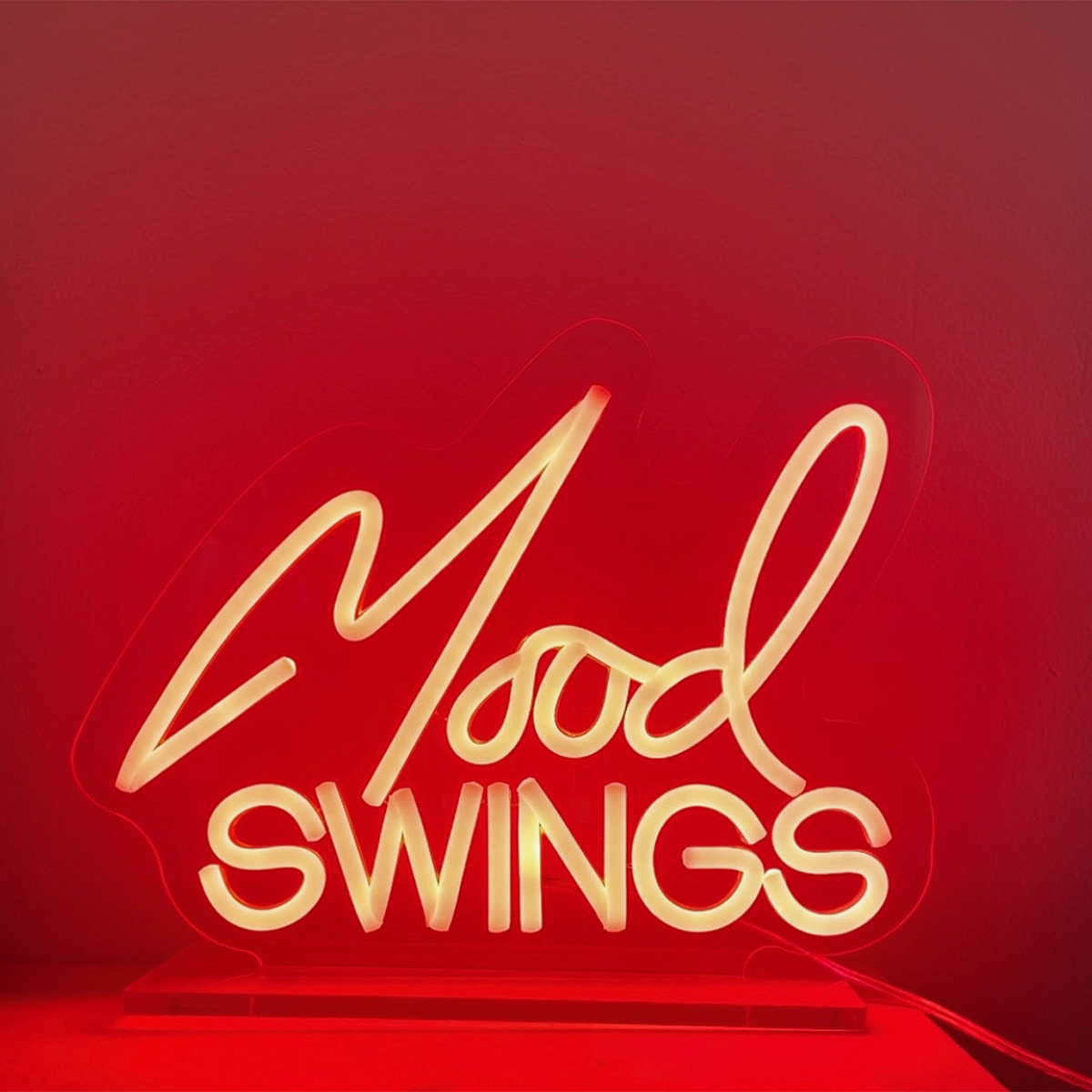 Neon sign displaying the words ’Mood Swings’ in cursive script.