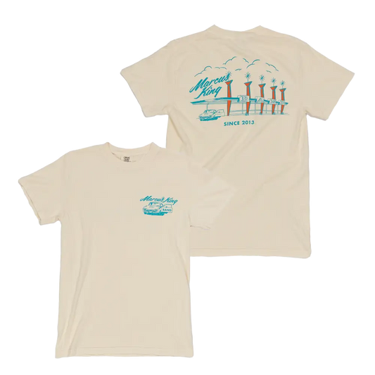 Beige t-shirt with a teal coastal design featuring piers or docks printed on the back.