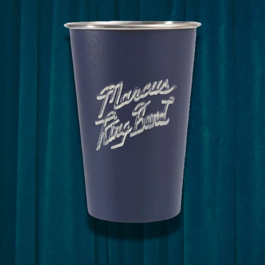 Purple cup with white text on a dark blue curtain background