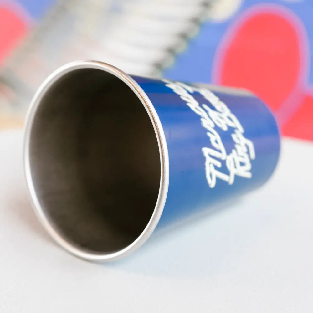Blue insulated tumbler with a silver rim and white cursive lettering.