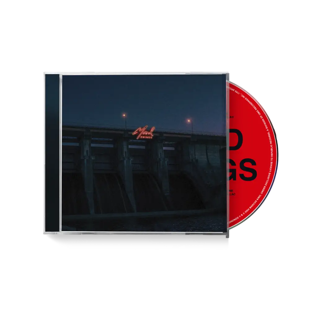 CD album case with a dark cover and red disc visible.