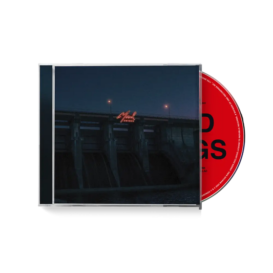 CD album case with a dark cover and red disc visible.