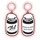 Two keychain pill bottle charms labeled ’Mood Swings’ with a pink glow effect.