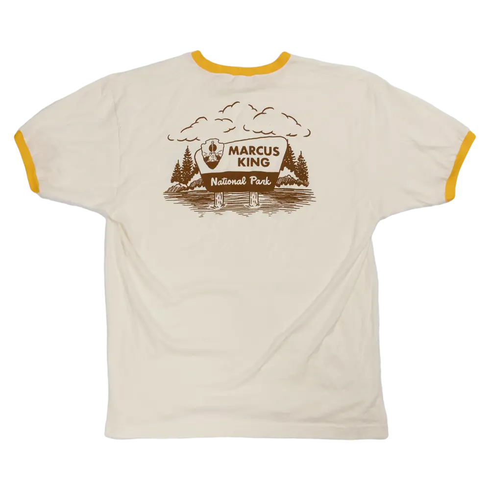T-shirt with a national park-themed graphic design featuring trees, mountains, and the text ’Marcus King National Park’.