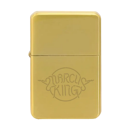 Gold-colored metal lighter with ’Marcus King’ engraved on its surface.